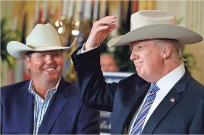  ?? ALEX BRANDON/AP ?? President Donald Trump tries on a Stetson hat with Dustin Noblitt, of Texas-based Stetson Hats, during a “Made in America” showcase Monday.