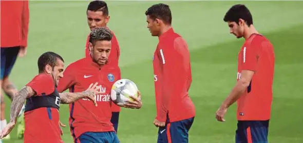  ?? AFP PIC ?? Neymar (ball in hand) with teammates during a training session at the Camp des Loges in Saint-Germain-en-Laye yesterday.