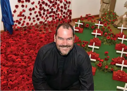  ?? Photo: Bev Lacey ?? CENTENARY: The Reverend Paul Mitchell among the display paying tribute to the centenary of the armistice, at the Soldier’s Chapel in St Luke’s Anglican Church.