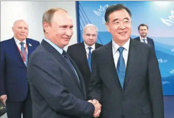  ?? MIKHAIL METZEL/ PHOTO VIA AP ?? Vice-Premier Wang Yang is greeted by Russian President Vladimir Putin in Vladivosto­k, Russia, on Wednesday.