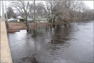  ?? Photos by Ernest A. Brown/The Call ?? Top photo: Crews from National Grid work to restore power to residents along Great Road in Lincoln Saturday, after large trees took down power lines during Friday’s nor’easter. Above: The swollen Pawtuxet River, as pictured from the Elmwood Avenue...