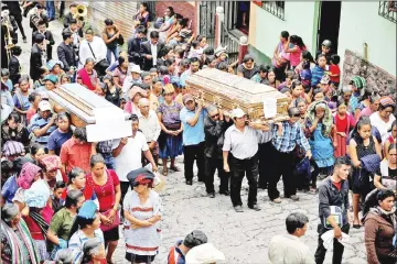  ??  ?? People carry the caskets of Maria Magdalena Zelada and Maritza Nij, who died during the eruption of the Fuego volcano. — Reuters photo