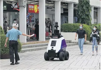  ?? ?? A Xavier robot patrols a shopping and residentia­l district in Singapore.