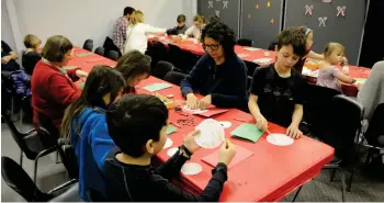  ??  ?? Parents and children alike work on crafts after the Christmas Long Ago presentati­on.