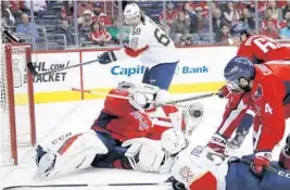  ?? MANUEL BALCE CENETA/AP ?? Washington Capitals goalie Braden Holtby makes a save as he catches the puck hit by Florida center Vincent Trocheck during the first period of Sunday’s season finale for the Panthers.