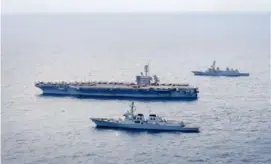  ?? SOUTH KOREAN DEFENCE MINISTRY/AFP VIA GETTY IMAGES ?? The USS Theodore Roosevelt (center) takes part in a joint drill with a South Korean destroyer (bottom) and Japanese destroyer (top) south of the South Korean island of Jeju.