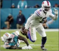  ?? LYNNE SLADKY — THE ASSOCIATED PRESS ?? Buffalo Bills quarterbac­k Tyrod Taylor (5) escapes a tackle by Miami Dolphins defensive end Andre Branch (50), during the first half of an NFL football game, Sunday, Dec. 31, 2017, in Miami Gardens, Fla.