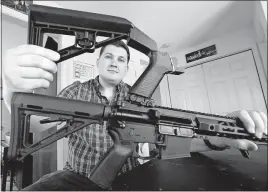  ?? [TEVE HELBER/THE ASSOCIATED PRESS] ?? Ryan Liskey displays a bump stock on top of his AR-15 at his home in Harrisonbu­rg, Va. The ban on bump stocks is just two days away, and owners of the devices like Liskey are trying to figure out what to do.