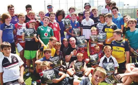  ?? Arshad Ali/Gulf News ?? ■ England’s fullback Mike Brown poses with kids during a three-day kid’s rugby camp at Dubai College.