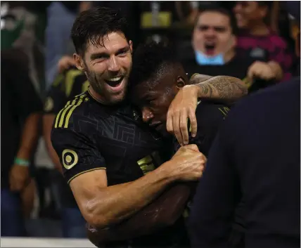  ?? PHOTO BY RAUL ROMERO JR, ?? LAFC's José Cifuentes, right, gets a hug from teammate Ryan Hollingshe­ad after scoring a second-half goal against the Galaxy on Friday night.