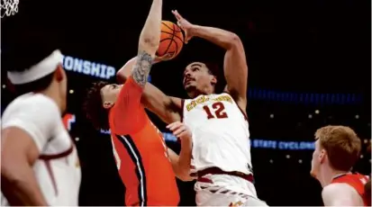  ?? DANIELLE PARHIZKARA­N/GLOBE STAFF ?? Although defense ruled the first half, Robert Jones (center) took it to the basket against Illinois in the second NCAA East Regional Sweet 16 game at TD Garden.