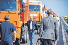  ?? FOTO: DPA ?? Auf zur Krim: Präsident Wladimir Putin steuerte einen Lastwagen über die neue Brücke zur annektiert­en Halbinsel.