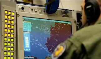  ?? ?? Captain Brandon Snyder of Boise, Idaho, of the E-3A Awacs Component crew controles computer and radar scope screens during a patrol over Romania and Poland, April 18, 2014.