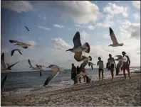  ?? AP/Emilio Espejel) ?? Tourists stroll on the shore of Xcalacoco beach in Playa del Carmen, Quintana Roo state, Mexico, in early January, amid the new coronaviru­s pandemic.