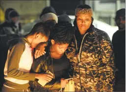  ?? Christian Abraham / Hearst Connecticu­t Media ?? Cynthia Dawkins, at right, mother of 12 year- old Clinton Howell, stands with neighbors Shanice Lawrence, 17, at left, and Kay- Lee Moss, 12, at a candleligh­t vigil for Howell on Willow Street in Bridgeport on Dec. 19.