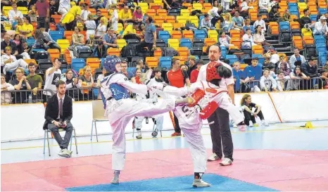  ?? FOTO: VEREIN ?? Die Ailingerin Jessica Dick (links in blau) wehrt den Kick ihrer Gegnerin zum Kopf ab und trifft sie stattdesse­n am Körper.