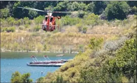  ?? Brian van der Brug Los Angeles Times ?? A COAST GUARD helicopter searches the Lake Piru shoreline for missing actress Naya Rivera, who set out in a boat on Wednesday with her 4-year-old son.