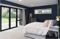  ??  ?? The master bedroom is painted midnight blue. ‘‘I wanted our room to be sort of masculine but still quite romantic,’’ Mrs Barron says.