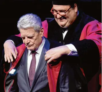  ?? Foto: Rainer Jensen, dpa ?? Nur der äußere Anlass seiner Abschiedsr­ede: Der Präsident der Universitä­t von Maastricht, Martin Paul, verleiht dem scheidende­n Bundespräs­identen Joachim Gauck hier die Ehrendokto­rwürde.