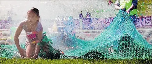  ?? PHOTOS / STUART MUNRO ?? The netting and the hoses made the Whanganui Tough Kid Challenge as tough as ever yesterday.