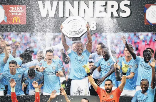  ?? PHOTO: REUTERS ?? Carrying on from last season . . . Manchester City players celebeate with the Community Shield after beating Chelsea 20 at Wembley yesterday.