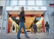  ?? PATRICK T. FALLON/BLOOMBERG ?? Pedestrian­s walk past the Tesla Motors store in Santa Monica, Calif.