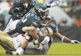  ?? Michael Perrez / Associated Press ?? C.J. Beathard is sacked by the Eagles' Brandon Graham (55) and Mychal Kendricks (right).