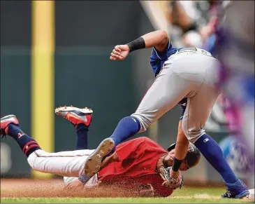  ?? PHOTOS BY HANNAH FOSLIEN / GETTY IMAGES ?? Ronald Guzman of the Rangers tags out the Twins’ Eddie Rosario on a fourth-inning pickoff play initiated by pitcher Isiah Kiner-Falefa. Rosario had led off the inning with a single to center.