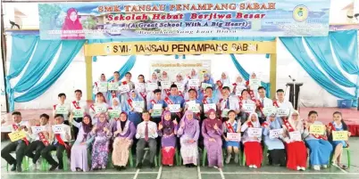  ??  ?? ZAIDI (tujuh kiri) dan Siti Salmiah (tengah) serta para Penolong Kanan bergambar kenangan bersama-sama para pelajar cemerlang SPM 2018 SMK Tansau, Penampang.