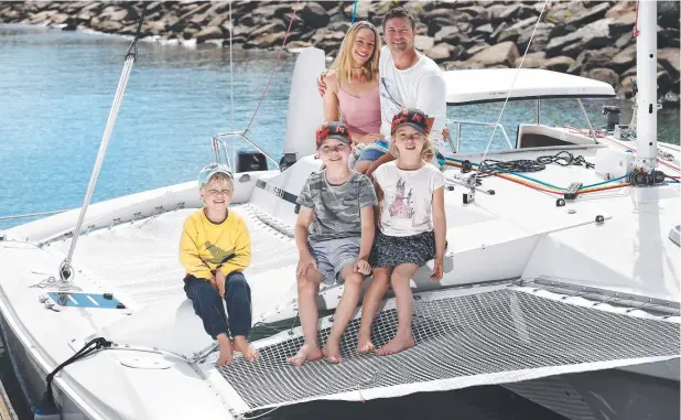  ?? Pictures: BRENDAN RADKE ?? PLAIN SAILING: Fleur and Angus Sharpe of Redlynch, with their three children Robert, 4, Harry, 8, and Josephine, 5, launch their yacht for its maiden voyage from the existing boat ramp at Half Moon Bay.