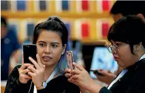  ?? PHOTO: REUTERS ?? Shoppers try the iPhone 8 Plus at the Apple Orchard Shop in Singapore.