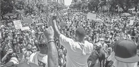  ?? RICARDO B. BRAZZIELL/ USA TODAY NETWORK ?? Thousands of people gather in front of the Texas Capitol in Austin about two weeks after George Floyd’s death, chanting, “Black lives matter” and “Justice.” Similar protests happened across America.