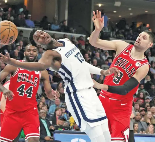  ?? KAREN PULFER FOCHT/AP ?? Bulls center Nikola Vucevic (right, guarding the Grizzlies’ Jaren Jackson Jr.) had 28 points and 17 rebounds in DeMar DeRozan’s absence Tuesday.