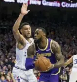  ?? CHRIS SZAGOLA — THE ASSOCIATED PRESS ?? The Lakers’ LeBron James, right, makes his move against the 76ers’ Ben Simmons, left, during the first half Sunday.