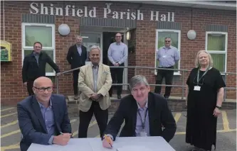  ?? Picture: Jess Warren ?? (From left) At the table: Mike Wilde, operations director at LifeBuild Solutions, Cllr Andrew Grimes, chair of Shinfield Parish Council both sign the contract. Behind: Tom Coward, director of AOC Architectu­re, Mike O'Hanlon, MEA project manager, Cllr Parry Batth, executive member for environmen­t and leisure at WBC, Mark Redfearn, head of localities at WBC, Mike Balbini, Shinfield Parish clerk, and Dawn Peer, councillor for Spencers Wood South