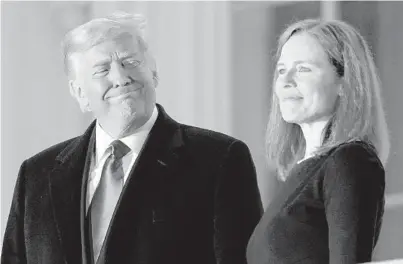  ??  ?? President Trump and new Justice Amy Coney Barrett rejoice after she took the constituti­onal oath Monday night.