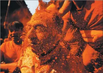  ?? NAVESH CHITRAKAR / REUTERS ?? A devotee gets his face smeared with vermillion powder during the “Sindoor Jatra” festival at Thimi, in Bhaktapur, Nepal, on Sunday.