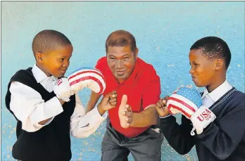  ?? Picture: WERNER HILLS ?? SQUARING UP: Apostle Gregory Leen, centre, hopes to take a jab at drugs and gangsteris­m in Helenvale through his boxing clinic. With him are Sheldon Krige, 10, left, and Nigel Job, 11