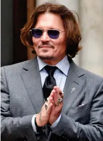  ??  ?? Smile: Johnny Depp after yesterday’s hearing