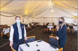  ??  ?? Valdenir Machado, general manager, and Serena Gipson, sales manager, pose in the Fogo de Chao dining tent. “We’re just trying to be creative and be smart about our business,” said Machado.