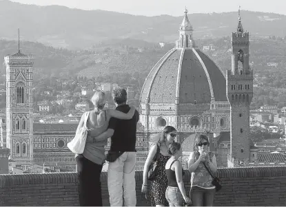  ?? Associated Press ?? A couple looks at the Florence Santa Maria del Fiore Basilica, with Giotto’s bell tower, left, Brunellesc­hi’s dome, from Forte Belvedere, Italy. “When they get to these more dramatic occasions, so many couples want to do something exciting and...