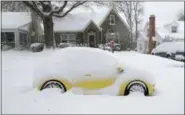  ?? CHUCK BURTON — THE ASSOCIATED PRESS ?? A snow-covered car is parked outside a home in Greensboro, N.C., Sunday. A massive storm brought snow, sleet, and freezing rain across a wide swath of the South on Sunday - causing dangerousl­y icy roads, immobilizi­ng snowfalls and power losses.