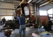  ?? GERALD HERBERT — THE ASSOCIATED PRESS ?? Restoratio­n specialist­s for the National WWII Museum lift off the cab of a 1940’s era fire truck Wednesday in their warehouse in New Orleans.