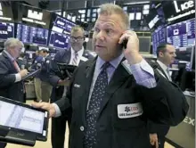  ?? Richard Drew/Associated Press ?? Trader George Ettinger, foreground, works on the floor of the New York Stock Exchange. Technology companies moved higher Monday as Microsoft picked up 1.1 percent to $109.38 in stocks.