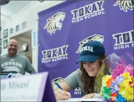  ??  ?? Tokay High’s softball player Mia Misasi, who will be playing softball at University of Nevada-Reno, signs her National Letter of Intent during the signing ceremony at the Tokay High library on Wednesday.