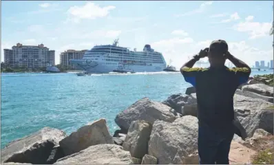  ?? GASTON DE CARDENAS / AFP ?? A man takes a smartphone photo of the Fathom cruise ship Adonia as she departs Miami Beach, Florida, on an inaugural seven-day voyage to Cuba on Sunday. It marked a new milestone in the rapprochem­ent between Washington and Havana.