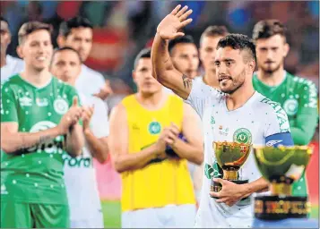  ??  ?? Chapecoens­e's defender Alan Ruschel waves to Barcelona players as he holds the second place trophy after the 52nd Joan Gamper Trophy friendly football match against Barcelona FC at the Camp Nou stadium in Barcelona