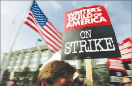  ?? FILE ?? In this Nov. 9, 2007 photo, Writers Guild of America writers and others strike against the Alliance of Motion Picture and Television Producers in a rally in Los Angeles. A tentative deal was reached between screenwrit­ers and producers Tuesday, averting...