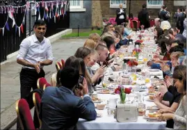  ?? (Photo AFP) ?? L’heure était à la conviviali­té, hier au Royaume-uni, jusqu’au plus haut niveau de l’état. À Downing Street, le Premier ministre Rishi Sunak (à gauche), a ainsi servi un repas à des bénévoles, des réfugiés ukrainiens, des jeunes... et Jill Biden.