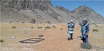  ?? PHIL JOHNSON / STUFF ?? Left, Baskul, who lost two children, and Tohira, who lost two children, at the Bamyan cemetery, and, right, the faces of Hussain Khudabakhs­h, Hussain Bakhsh Mohammad, Amina Nowruz, and two unknown children, are testment to the devices left behind on firing ranges in Afghanista­n which are, above, still being cleared.